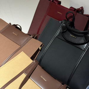 A collection of luxury handbags from Balenciaga, including a black leather tote with a gold logo, a dark red leather tote, and several brown and beige textured satchels, arranged closely together.